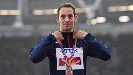 Le perchiste français Renaud Lavillenie reçoit la médaille de bronze aux Mondiaux d'athlétisme de Londres (Royaume-Uni), le 9 août 2017. (BEN STANSALL / AFP)