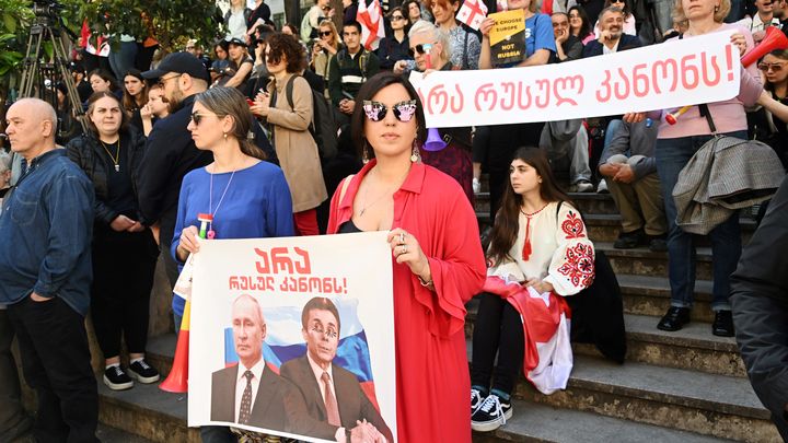 A protester in Tbilisi carrying a sign depicting portraits of Vladimir Putin and Bidzina Ivanishvili under the inscription: "no to Russian law".  (VANO SHLAMOV / AFP)