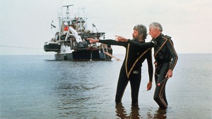 L'océanographe Jacques-Yves Cousteau et son fils Jean-Michel, près de leur navire "Calypso". Photo non datée (HANDOUT / THE COUSTEAU SOCIETY)