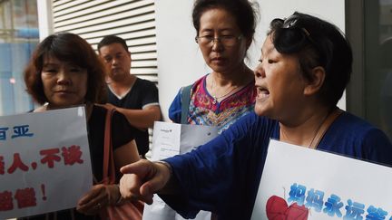 Des proches de passagers du vol MH370 r&eacute;clament des explications devant le si&egrave;ge chinois de Malaysia Airlines, &agrave; P&eacute;kin (Chine), le 6 ao&ucirc;t 2015. (GREG BAKER / AFP)