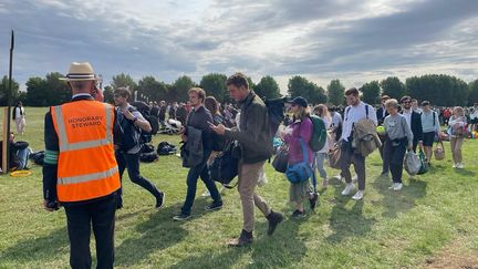 Les honorary stewards, ou les bénévoles du tournoi, guident les spectateurs en quête de billet, dans la célèbre "Queue". (APOLLINE MERLE / FRANCEINFO SPORT)