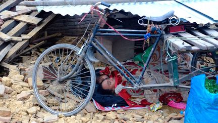 D'autres, comme ce p&egrave;re et sa fille, dorment au milieu des d&eacute;combres, &agrave; proximit&eacute; de leurs derniers biens. (SUNIL PRADHAN / ANADOLU AGENCY / AFP)