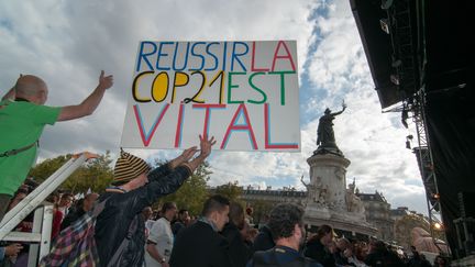 Un homme tient une pancarte enjoignant les Etats &agrave; trouver un accord sur le climat, le 26 septembre 2015, place de la R&eacute;publique &agrave; Paris. (SERGE TENANI / CITIZENSIDE / AFP)