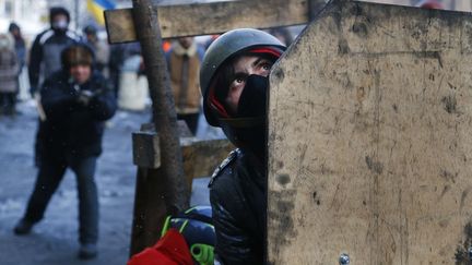 Des manifestants se prot&egrave;gent derri&egrave;re des boucliers, &agrave; Kiev, le 23 janvier 2014. (SERGEI GRITS / AP / SIPA)