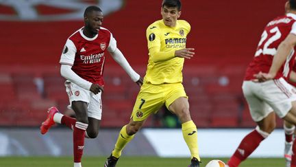 Le joueur d'Arsenal Nicolas Pepe à la course derrière Gerard Moreno (Villareal), le 6 mai 2021 à l'Emirates Stadium. (ADRIAN DENNIS / AFP)