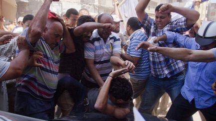 Des partisans du pr&eacute;sident &eacute;gyptien Mohammed Morsi tabassent un opposant au r&eacute;gime &agrave; Damietta (Egypte), le 3 juillet 2013. (HAMADA ELRASAM / AP / SIPA)