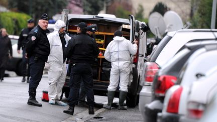 Policiers et m&eacute;decins l&eacute;gistes&nbsp;devant l'immeuble o&ugrave; vivait Mohamed Merah, le 22 mars 2012, &agrave; Toulouse.&nbsp; (PASCAL PAVANI / AFP)