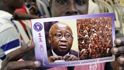 Un partisan de Laurent Gbagbo brandit un tract à l'effigie de l'ancien président ivoirien, où l'on peut lire «11 avril - Solidarité avec Laurent Gbagbo», pendant une manifestation le 11 avril 2015 marquant l'anniversaire de son l'arrestation


 (AFP PHOTO/SIA KAMBOU)