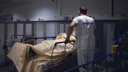 Un médecin au chevet d'un malade du Covid-19 à l'hôpital de Perpignan (Pyrénées-Orientales), le 4 juillet 2022. (ARNAUD LE VU / HANS LUCAS / AFP)