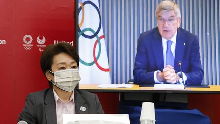 Seiko Hashimoto, la présidente de Tokyo 2020, et Thomas Bach (sur écran),&nbsp;le président du Comité international olympique (CIO), conversent lors d'une conférence de presse, le 21 juin 2021.&nbsp; (RODRIGO REYES MARIN / POOL)