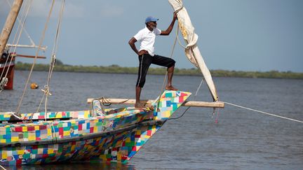 Un marin&nbsp; du "Flipflopi" se tient à la proue de ce bateau presqu'entièrement réalisé en plastique recyclé, lors de son lancement sur l'île de Lamu en septembre 2018. (BAZ RATNER / X02483)