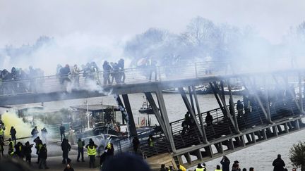 Heurts entre "gilets jaunes" et forces de l'ordre sur la passerelle Leopold-Senghor, à Paris, le 5 janvier 2019.&nbsp; (KAMIL ZIHNIOGLU / AP / SIPA)