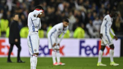 L'immense déception d'Alexandre Lacazette, le visage enfoui dans son maillot, après l'élimination de l'Olympique Lyonnais en demi-finales de la Ligue Europa face à l'Ajax Amsterdam (1-4, 3-1).  (JEFF PACHOUD / AFP)