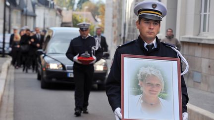 Un policier porte le portrait d'Anne Pavageau, le 20 octobre 2011 &agrave; Bourges (Cher), lors des obs&egrave;ques de la polici&egrave;re tu&eacute;e dans l'exercice de ses fonctions le 14 octobre 2011 par un forcen&eacute; arm&eacute; d'un sabre. (ALAIN JOCARD / AFP)