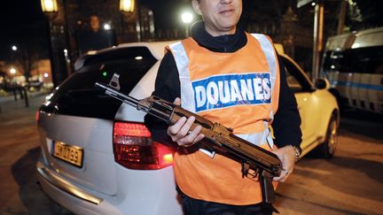 Un agent des douanes montre une kalachnikov trouv&eacute;e dans le coffre d'un v&eacute;hicule, le 22 novembre 2010, &agrave; Marseille (Bouches-du-Rh&ocirc;ne). (ANNE-CHRISTINE POUJOULAT / AFP)