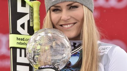 La skieuse Lindsey Vonn avec le petit globe de la descente, remporté le 16 mars 2016 à Saint Moritz. (FABRICE COFFRINI / AFP)