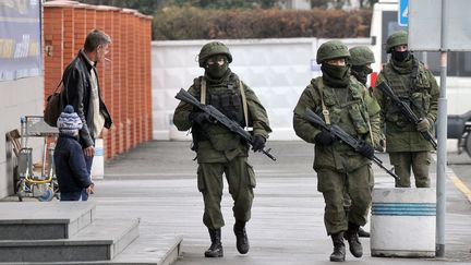 Des hommes arm&eacute;s patrouillent autour de l'a&eacute;roport de Simferopol, le 28 f&eacute;vrier 2014, en Crim&eacute;e (Ukraine).&nbsp; (GENYA SAVILOV / AFP)