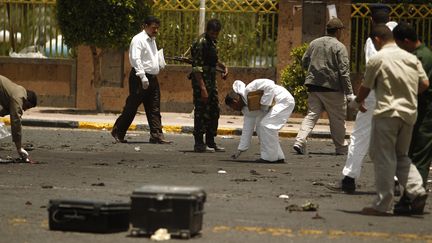 Des enqu&ecirc;teurs collectent des indices sur les lieux de l'attaque suicide qui a ensanglant&eacute; Sanaa (Y&eacute;men), le 21 mai 2012. (KHALED ABDULLAH ALI AL MAHDI / REUTERS)