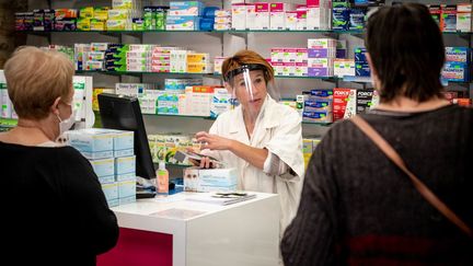 Une pharmacienne face à des clients, dans une officine de Dordogne, le 15 mai 2020. (GARO / PHANIE / AFP)