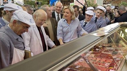 Marine Le Pen discutant avec un boucher le 25 février 2011 lors du salon de l'agriculture à Paris (AFP PHOTO MIGUEL MEDINA)