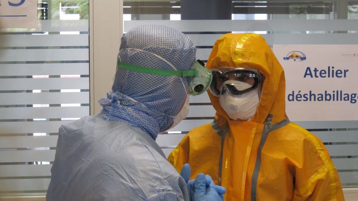 Deux membres du personnel soignant du Samu de Paris, l'un d'eux v&ecirc;tu d'une combinaison l&eacute;g&egrave;re (G), l'autre d'une combinaison int&eacute;grale, vendredi 24 octobre 2014, &agrave; l'h&ocirc;pital Necker, &agrave; Paris. (LOUIS BOY / FRANCETV INFO)