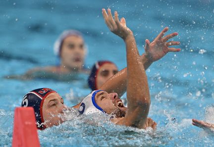 Le Serbe Nemanja Ubovic à la lutte avec l'Américain Hannes Daube, lors de la demi-finale du tournoi olympique de water-polo, à l'Arena de Paris La Défense, le 9 août 2024. (ANDREAS SOLARO / AFP)