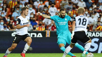 Karim Benzema (Real Madrid) tente de frapper devant Daniel Wass (Valence) en Liga, au Stade Mestella, le 19 septembre 2021 (JOSE JORDAN / AFP)