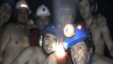 Sept des trente-trois mineurs chiliens coincés à 688 mètres de profondeur dans une mine de San José prennent la pose, le 17 septembre 2010. Leur sauvetage miraculeux, après 69 jours passés sous terre, a&nbsp;été adapté au cinéma en 2015. (OFICCIAL TV MINISTERY MINE / AFP)