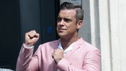 Sur le tournage de son nouveau clip "Vertigo", Robbie Williams joue les gros bras en costume rose. Impressionnant. (MICHAEL GRAAE / NATIONAL PICTURES / MAXPPP)