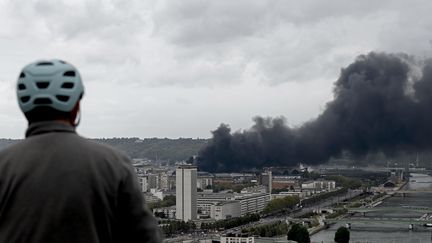 Un homme regarde l'incendie au loin de l'usine Lubrizol à Rouen, le 26 septembre 2019. (PHILIPPE LOPEZ / AFP)