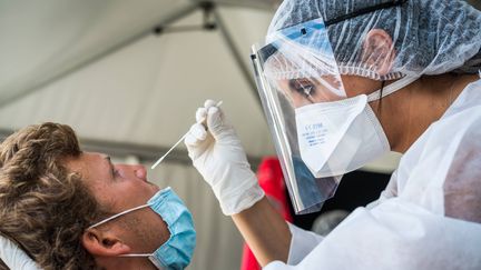 Un homme passe un test PCR de dépistage du coronavirus dans une tente sur le parvis de l'hôtel de ville, à Paris, le 4 septembre 2020. (VOISIN / PHANIE / AFP)