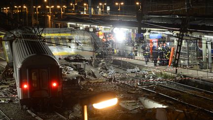 Des secouristes s'affairent apr&egrave;s le d&eacute;raillement d'un train Paris-Limoges qui a fait sept morts et des dizaines de bless&eacute;s, le 12 juillet 2013, en gare&nbsp;de Br&eacute;tigny-sur-Orge (Essonne). (LIONEL BONAVENTURE / AFP)