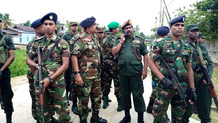 Des soldats prennent la garde près du lieu de l'assaut mené contre&nbsp;une cache supposée de membres du groupe Etat islamique, samedi 27 avril à Kalmunai (Sri Lanka). (STRINGER / AFP)