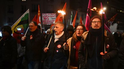 Des manifestants ont défilé, flambeau à la main, contre la réforme des retraites à Paris, le 26 janvier 2023. (EMMANUEL DUNAND / AFP)