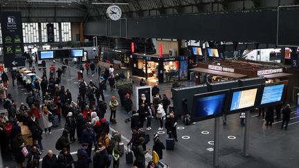 Des voyageurs dans la gare de l'Est à Paris, le 24 janvier 2023. (THOMAS SAMSON / AFP)