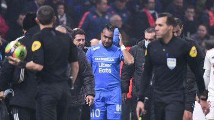 Le&nbsp;milieu de terrain&nbsp;de l'Olympique de Marseille, Dimitri Payet, quitte le terrain après avoir été blessé par un jet de bouteille à la tête lors d'un match de Ligue 1 contre l'Olympique Lyonnais au Groupama Stadium de Décines-Charpieu, le 21 novembre 2021.&nbsp; (PHILIPPE DESMAZES / AFP)