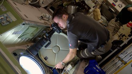 Le spationaute Thomas Pesquet prend une photo depuis un hublot de la Station spatiale internationale, le 28 décembre 2016. (PICASA / AFP)