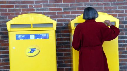 Une femme poste son courrier dans une bo&icirc;te aux lettres, le 22 mai 2009 &agrave; Poitiers (Vienne). &nbsp; (MAXPPP)