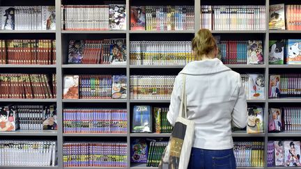 400 auteurs de BD signent une pétition dans Libération contre la précarisation de leur profession. Ci-contre, une jeune fille regarde des mangas lors du 43e Festival d'Angoulême en janvier 2016. (GEORGES GOBET / AFP)