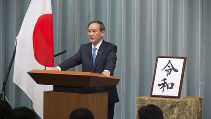 Le secrétaire général du Cabinet, Yoshihide Suga, annonce le nom de la nouvelle ère impériale, lors d'une conférence de presse, à Tokyo (Japon), le 1er avril 2019. (KAZUHIRO NOGI / AFP)