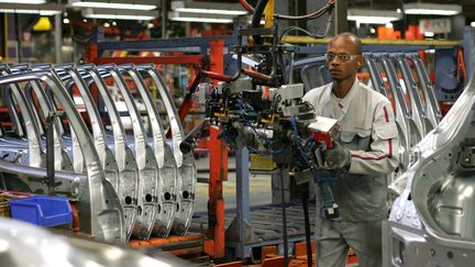 Un ouvrier de l'usine PSA de Mulhouse (Haut-Rhin) travaille sur une cha&icirc;ne de montage, le 11 juin 2009. (DENIS SOLLIER /&nbsp;L'ALSACE / MAXPPP)