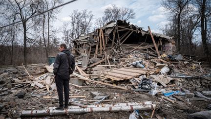 Un homme observe les débris d'un bâtiment endommagé à Kostyantynivka (Ukraine), le 24 mars 2023. (IGNACIO MARIN / ANADOLU AGENCY / AFP)