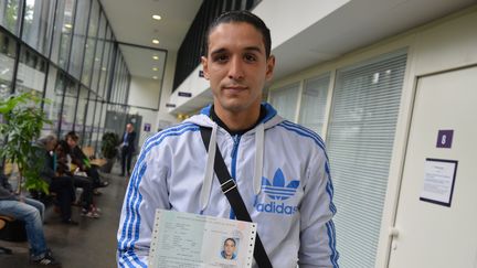 Mohssen Oukassi pose avec son r&eacute;c&eacute;piss&eacute; de demande de carte de s&eacute;jour, le 17 juin 2014, &agrave; la pr&eacute;fecture de Seine-Saint-Denis, &agrave; Bobigny. (YANN THOMPSON / FRANCETV INFO)