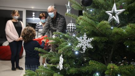 Un enfant reçoit un cadeau de Noël. Photo d'illustration. (JEAN-FRAN?OIS FREY / MAXPPP)