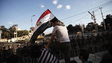 Un opposant &agrave; Mohamed Morsi franchit les barbel&eacute;s aux abords du palais pr&eacute;sidentiel, au Caire, le 7 d&eacute;cembre 2012. (GIANLUIGI GUERCIA / AFP)