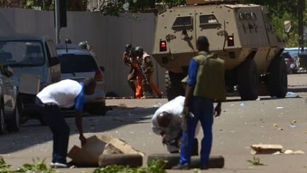 Des agents de sécurité se déplacent à côté d'un véhicule blindé à la suite de multiples attaques à Ouagadougou contre notamment le QG militaire qui ont causé la mort de 8 soldats et beaucoup d'autres blessés le 2 mars 2018.&nbsp; (Ahmed Ouoba/AFP)