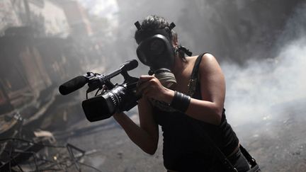 Un journaliste filme un incendie &agrave; Tegucigalpa (Honduras), le 18 f&eacute;vrier 2012. (JORGE DAN LOPEZ /REUTERS)