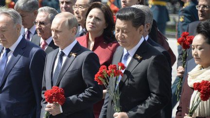 De droite à gauche, le président chinois Xi Jinping, le président russe Vladimir Poutine et le président kazakh Noursoultan Nazarbaïev vont déposer une gerbe sur la tombe du soldat inconnu près du mur du Kremlin, le 9 mai 2015, pour le 70e anniversaire de la victoire sur l'Allemagne nazie. (AFP Photo/Alexander Nemenov)