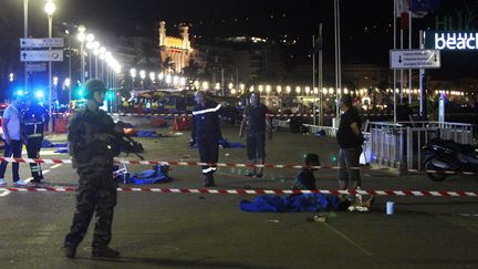 Des soldats montent la garde près de corps de victimes, après l'attaque meurtrière sur la promenade des Anglais à Nice, le 14 juillet 2016. (VALERY HACHE / AFP)