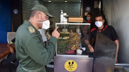 Les forces de sécurité demandent aux habitants&nbsp;de se conformer aux mesures&nbsp;sanitaires pour endiguer la propagation du coronavirus à Salé, au Maroc, le 27 décembre 2020. (JALAL MORCHIDI / ANADOLU AGENCY)